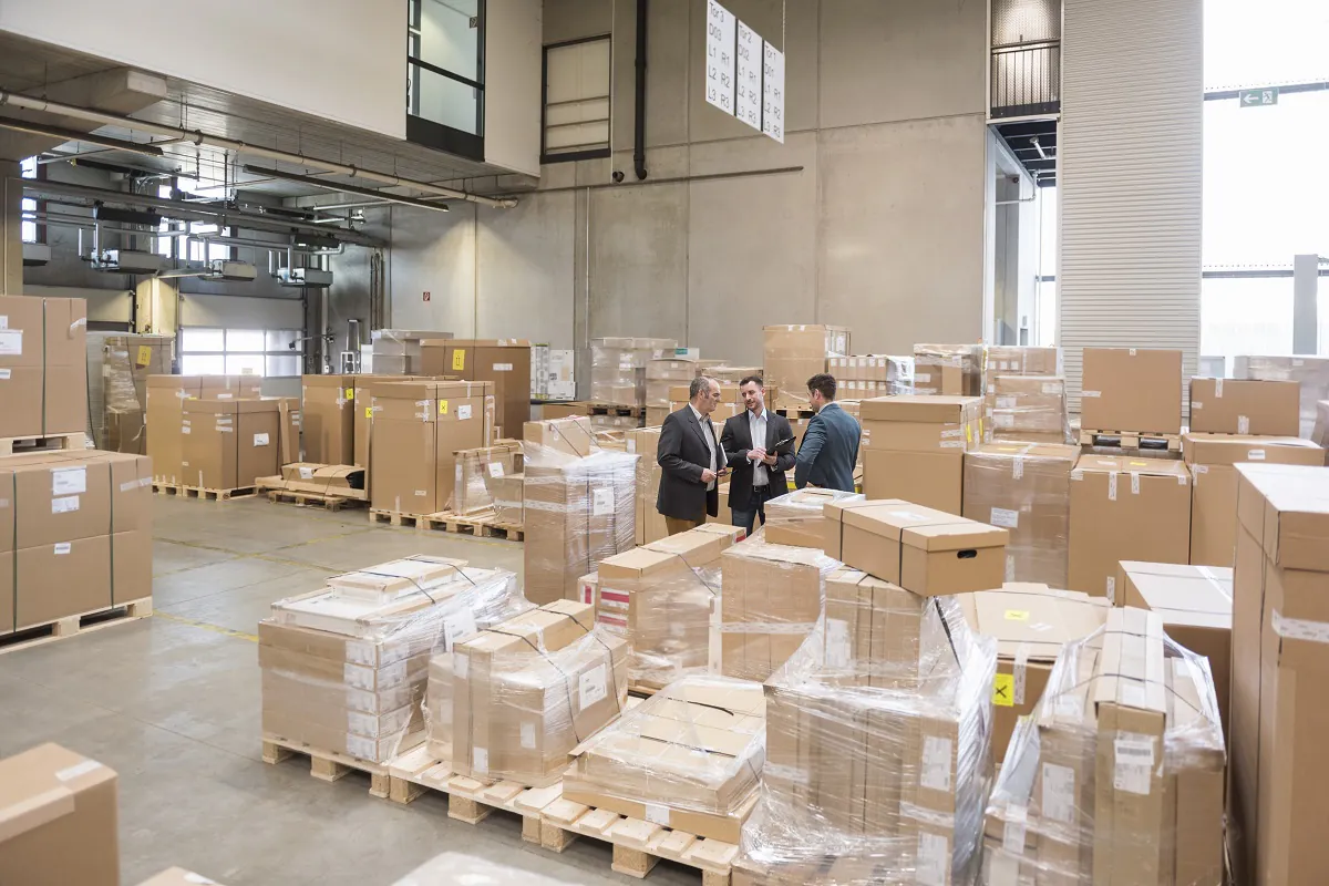 three men in factory warehouse surrounded by cardb 2024 09 22 10 57 02 utc
